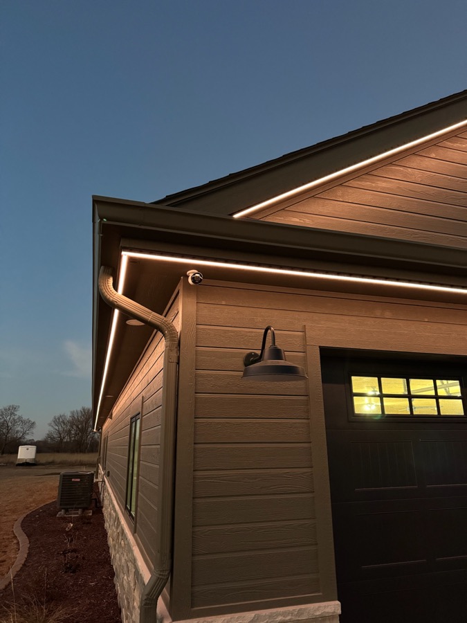 The same fixture at night, glowing warm white along the roofline